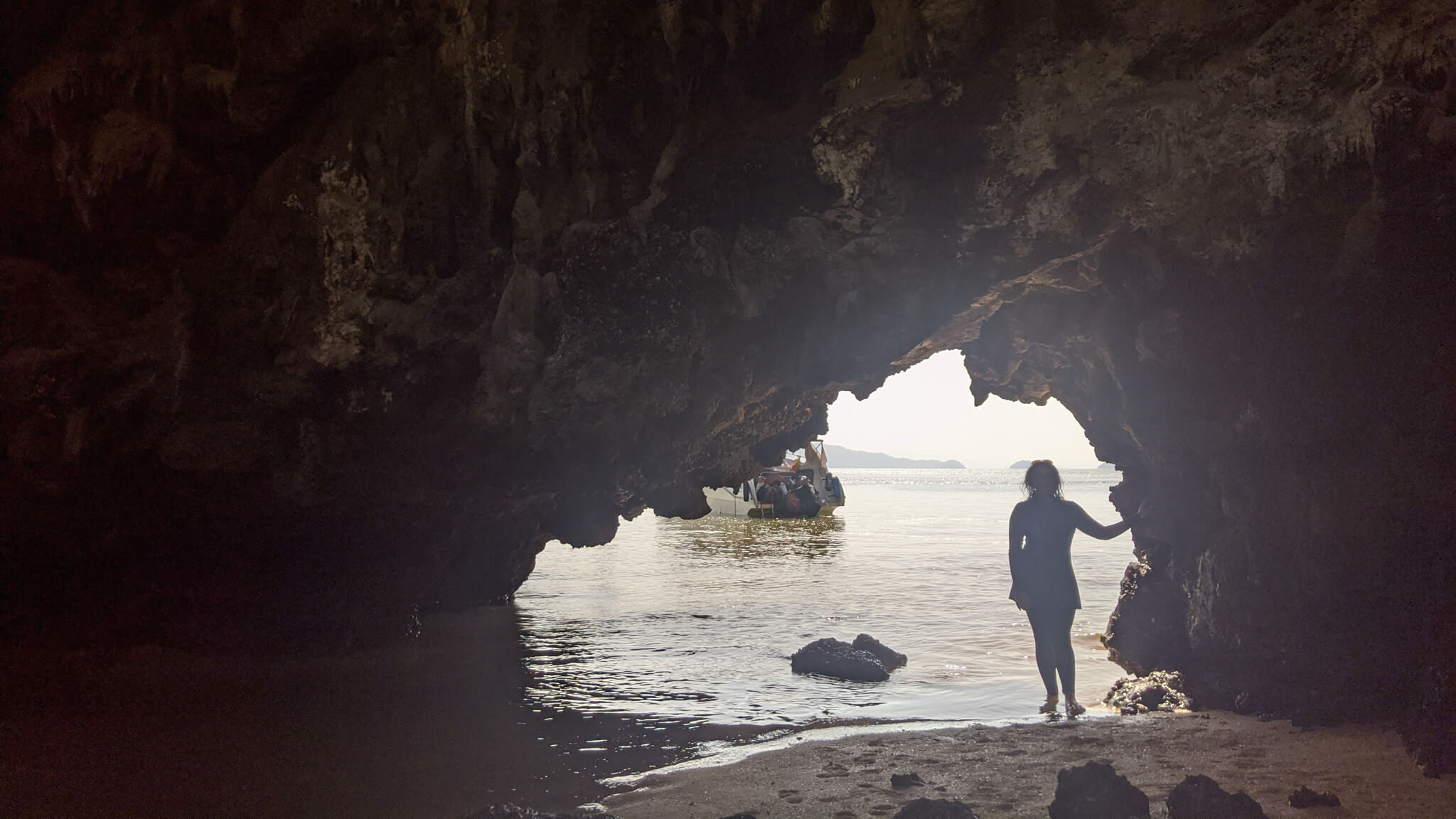 standing at the entrance of a cave in Thailand